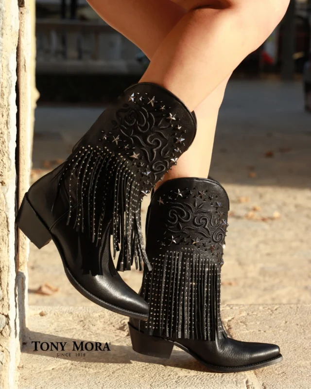 The rebellious side of elegance. 🇬🇧
These black boots with fringes, studs, and star-shaped embroidery are more than just footwear — they’re a bold statement.
For women who shine with confidence and walk with purpose.
Handcrafted in Mallorca from the finest leather and generations of artisanal expertise.
A stellar design. A timeless attitude.

Die rebellische Seite der Eleganz. 🇩🇪
Diese schwarzen Stiefel mit Fransen, Nieten und sternförmiger Stickerei sind mehr als nur Schuhe – sie sind ein starkes Statement.
Für Frauen, die mit Selbstvertrauen strahlen und ihren Weg entschlossen gehen.
Handgefertigt auf Mallorca aus bestem Leder und vollendet mit dem Können mehrerer Generationen.
Ein strahlendes Design. Eine zeitlose Haltung.

El lado más rebelde de la elegancia. 🇪🇸
Estas botas negras con flecos, tachuelas y bordado de estrellas no son solo calzado: son una declaración de estilo con carácter propio.
Para mujeres que brillan con seguridad y avanzan con determinación.
Hechas a mano en Mallorca con piel de máxima calidad y el saber hacer de generaciones de artesanos.
Un diseño estelar. Una actitud eterna.

#tonymoraboots #luxurywestern #handcraftedboots #MallorcaCraftsmanship #WesternElegance #IconicStyle #rebelliouselegance #timelessstyle #madeinmallorca #cowgirlchic #botasconactitud #estiloconhistoria #ArtesaníaConCarácter #EleganciaRebelde #diseñoestelar